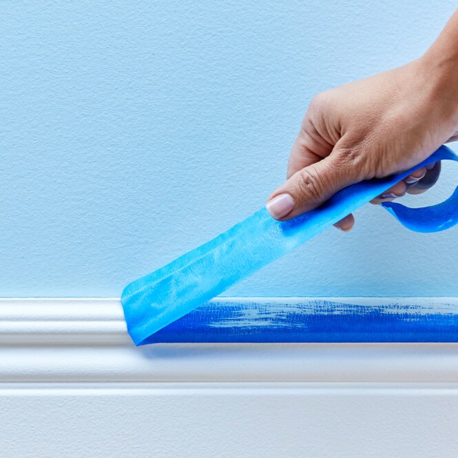 ScotchBlue™ Painter’s Tape being peeled off a base board.