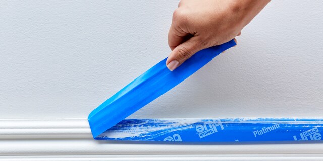 Retrait de ruban pour peintres ScotchBlue(MC) sur une plinthe.
